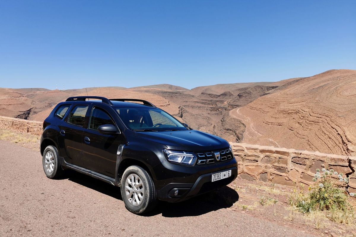 Black Dacia Duster hire car with hills in the background on a 7 day Morocco road trip.