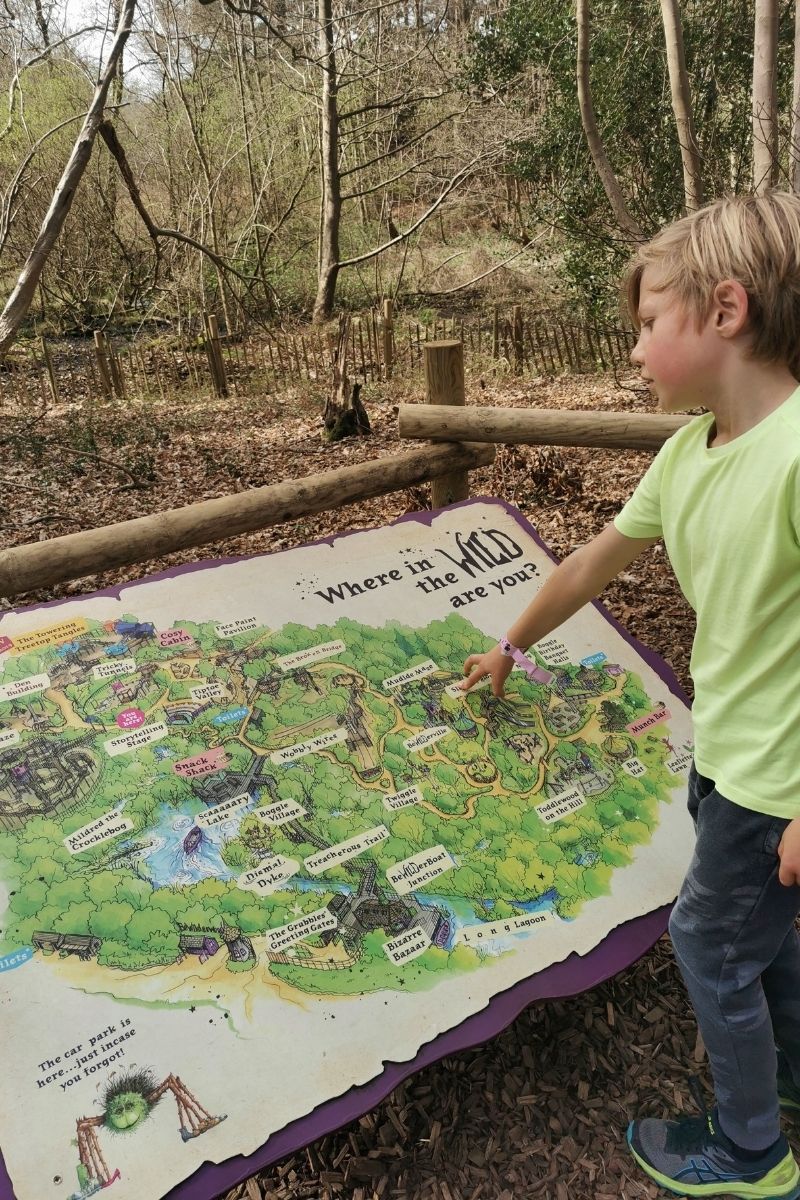 Boy pointing at a map of BeWILDerwood - one of the best things to do with kids in Norfolk.