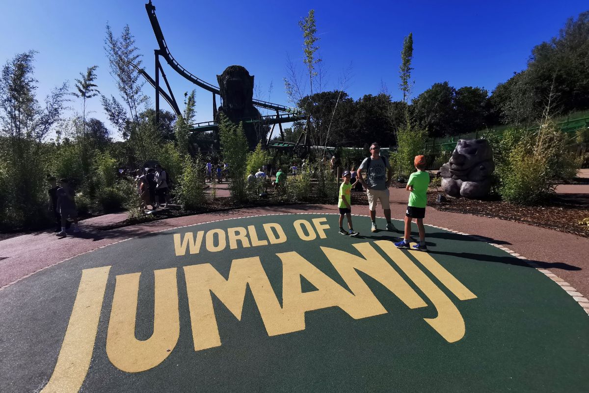 Family standing on the World of Jumanji sign at Chessington World of Adventures Resort.