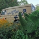Green rhino in front of a Chessington jeep.