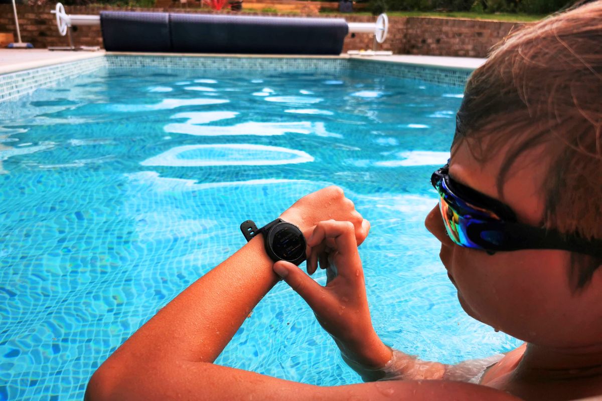 Young boy looking at the settings on his Garmin Venu 2 GPS Smartwatch for kids.