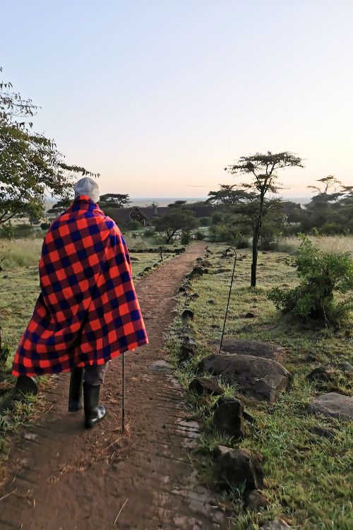 Masai warrior walking along a path at Naboisho Camp in the Masai Mara in Kenya.